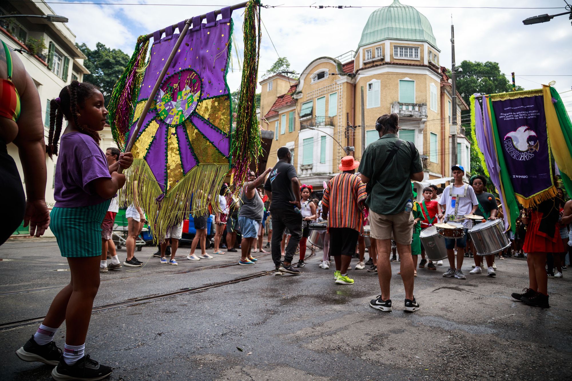 Cortejo de carnaval da Favela Brass com estandartes pelas ruas do Rio